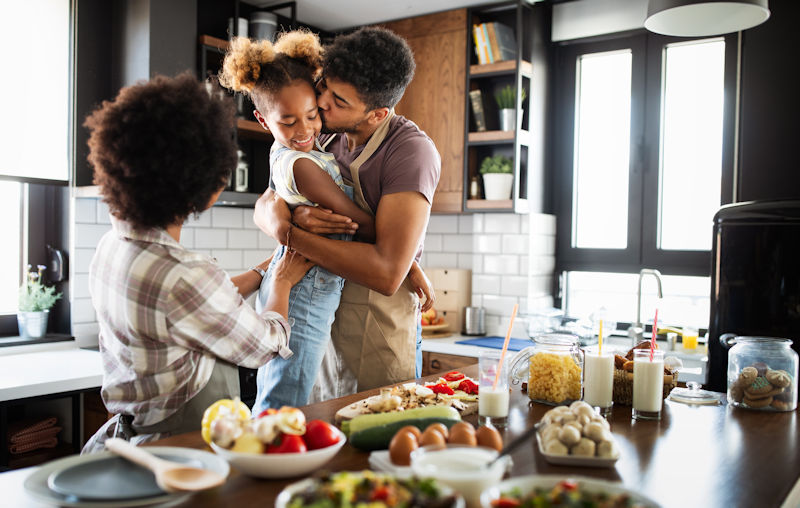 Happy family cooking together healthy food in the kitchen